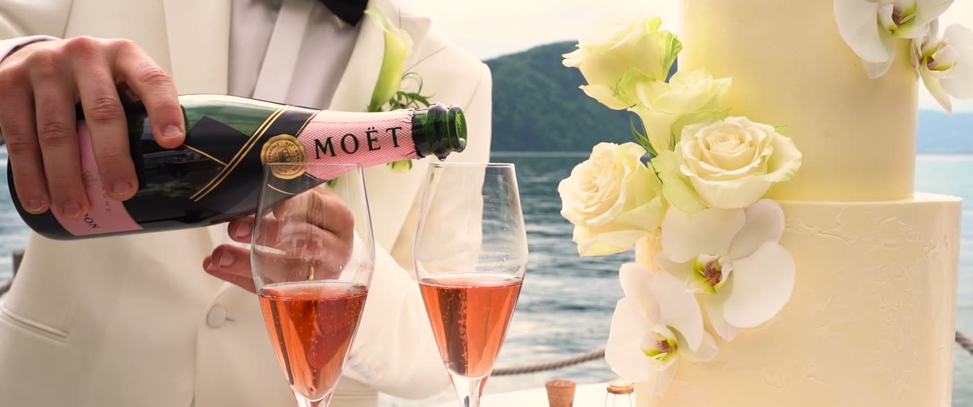 Champagner wird neben der Hochzeitstorte eingeschenkt